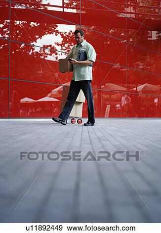 Stock Photo - A courier delivers parcels. Fotosearch