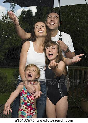 A family under an umbrella in the rain View Large Photo Image Stock Photography - A family under an umbrella in the rain. Fotosearch