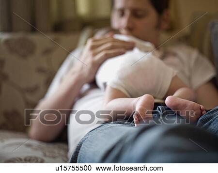 Stock Image - A father holding a new born baby. Fotosearch