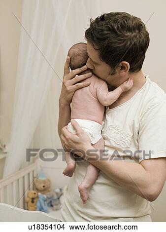 Picture - A father holding his new born baby. Fotosearch