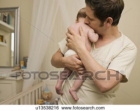 Stock Photograph - A father holding his new born baby. Fotosearch