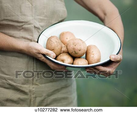 A female holding a bowl of potatoes View Large Photo Image Stock Image - A female holding a bowl of potatoes. Fotosearch