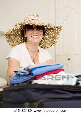 A female packing to go on holiday View Large Photo Image Stock Photo - A female packing to go on holiday. Fotosearch