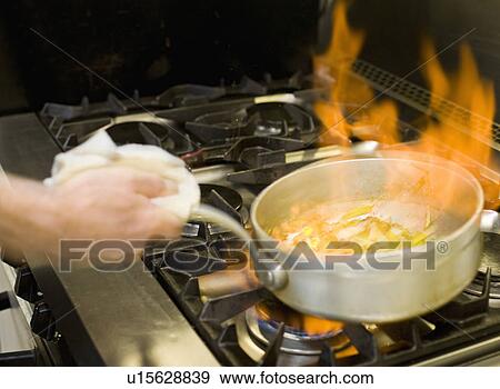 A flaming pan cooking on a hob View Large Photo Image Stock Photo - A flaming pan cooking on a hob. Fotosearch