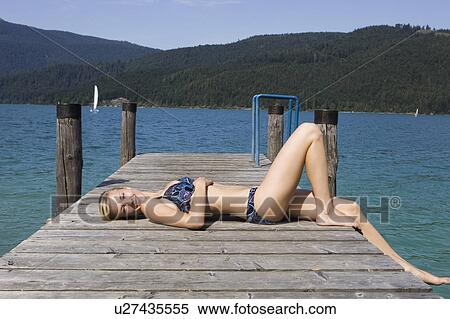 A girl relaxing on a pier by a lake View Large Photo Image Stock Photography - A girl relaxing on a pier by a lake. Fotosearch