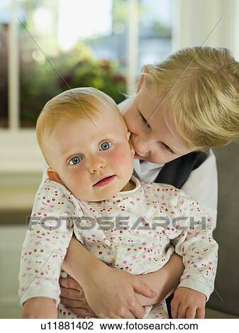 A little girl hugging her baby sister View Large Photo Image Stock Image - A little girl hugging her baby sister. Fotosearch