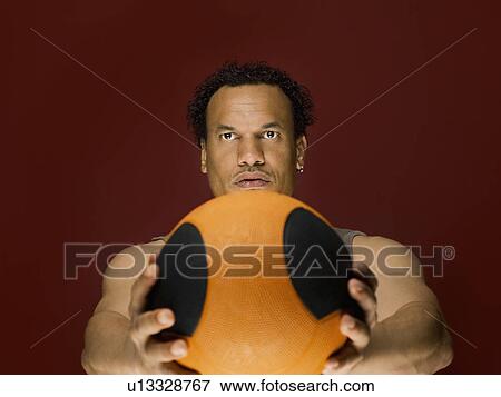 Stock Photo - A male holding a basket ball. Fotosearch