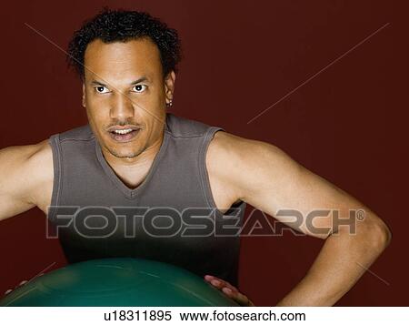 Stock Photography - A male working out using a ball. Fotosearch