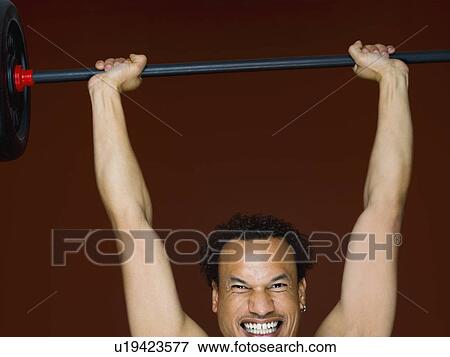 A male working out using weights View Large Photo Image Stock Photo - A male working out using weights. Fotosearch