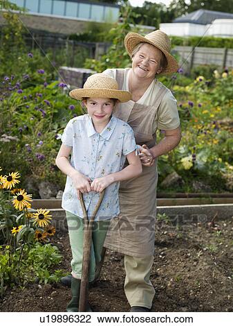 Stock Image - A mother and daughter in an allotment. Fotosearch