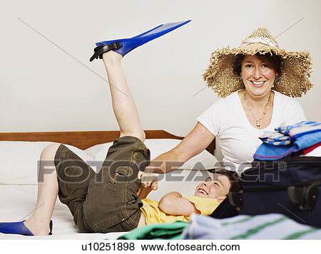 Stock Photo - A mother and son packing for holiday. Fotosearch