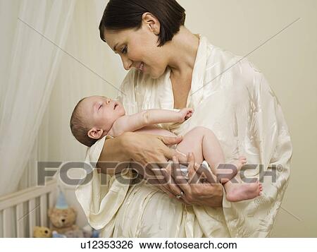 Stock Photograph - A mother holding a new born baby. Fotosearch