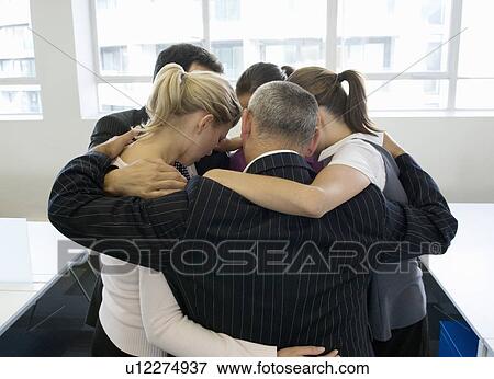Stock Photo - A portrait of a business team huddling. Fotosearch