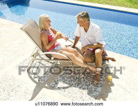A senior couple talking by the pool View Large Photo Image Stock Image - A senior couple talking by the pool. Fotosearch