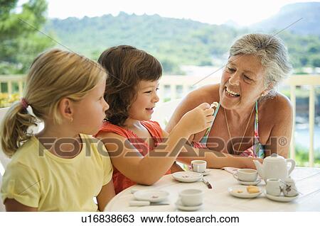 A senior female and children having tea View Large Photo Image Stock Image - A senior female and children having tea. Fotosearch