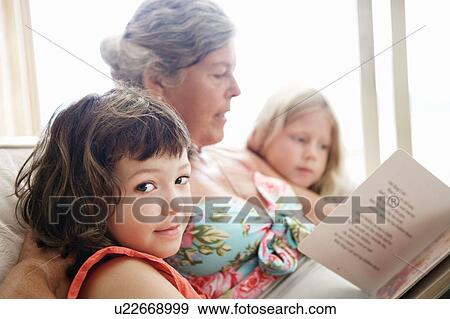 Stock Photo - A senior female reading to some children. Fotosearch