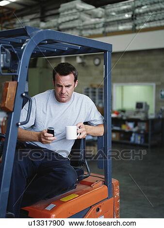 Stock Image - A warehouse manager takes a tea break. Fotosearch