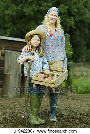 A woman and girl in a garden View Large Photo Image Stock Photo - A woman and girl in a garden. Fotosearch