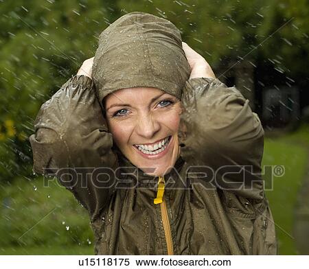 Stock Photography - A woman in the rain smiling. Fotosearch
