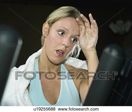 Stock Photo - A woman on a running machine. Fotosearch