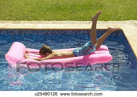 A young boy diving on to an inflatable View Large Photo Image Stock Photograph - A young boy diving on to an inflatable. Fotosearch