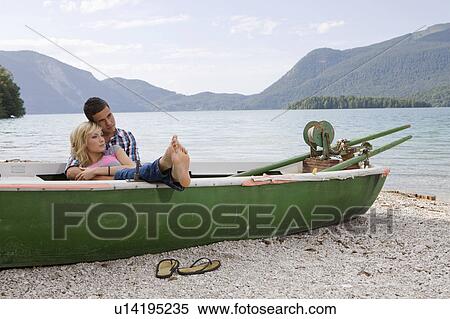 Stock Photography - A young couple daydreaming in a boat. Fotosearch