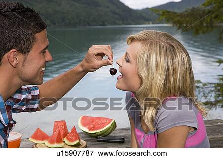A young couple having a picnic by a lake View Large Photo Image Stock Photo - A young couple having a picnic by a lake. Fotosearch
