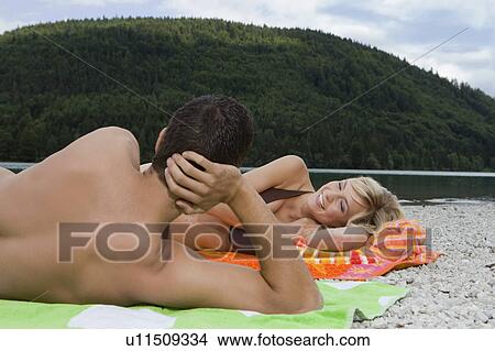 A young couple having fun by a lake View Large Photo Image Picture - A young couple having fun by a lake. Fotosearch