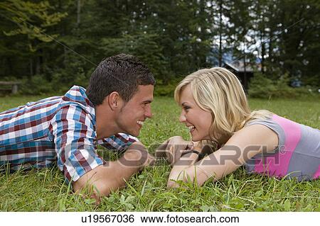 Stock Photograph - A young couple laughing at each other. Fotosearch