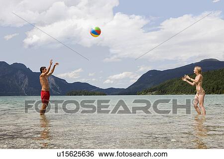 A young couple playing with a beach ball View Large Photo Image Stock Photograph - A young couple playing with a beach ball. Fotosearch
