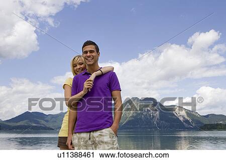 A young couple smiling towards camera View Large Photo Image Stock Image - A young couple smiling towards camera. Fotosearch