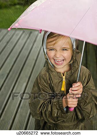 Stock Image - A young girl under an umbrella. Fotosearch