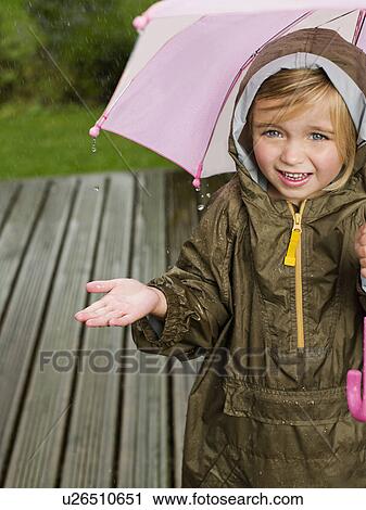 A young girl under an umbrella View Large Photo Image Stock Image - A young girl under an umbrella. Fotosearch