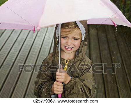 A young girl under an umbrella View Large Photo Image Stock Photo - A young girl under an umbrella. Fotosearch