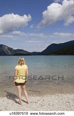 A young woman standing by a lake View Large Photo Image Stock Photo - A young woman standing by a lake. Fotosearch