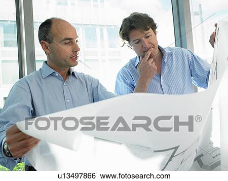 Stock Photograph - Architects looking at blue prints. Fotosearch