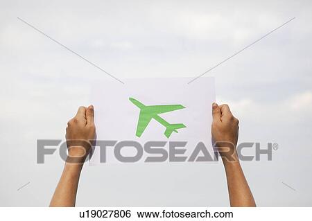 Stock Photograph - Arms holding paper green plane. Fotosearch