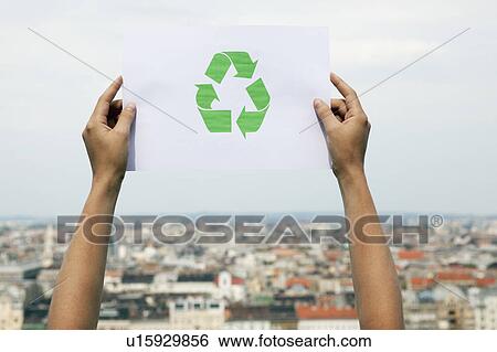 Stock Photograph - Arms holding paper green recycling sign. Fotosearch