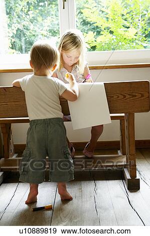 Stock Photo - Baby boy and his sister drawing. Fotosearch