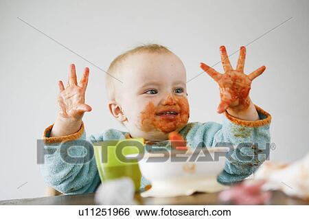 Stock Photograph - baby full of tomato sauce. Fotosearch