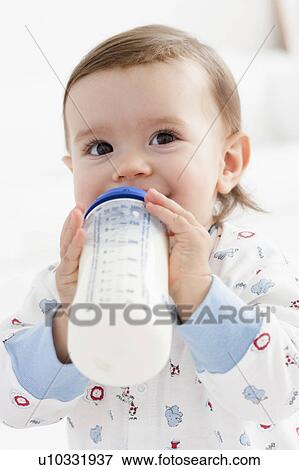 Stock Photo - baby girl drinking milk. Fotosearch