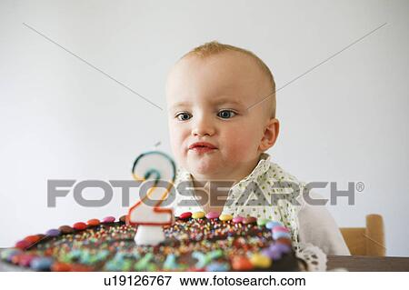 Stock Photo - baby laughing with birthday cake. Fotosearch