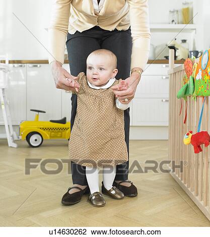 Stock Image - Baby learning to walk. Fotosearch