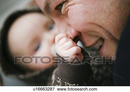 Stock Photo - baby picking nose of father. Fotosearch