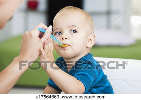 baby sitting in chair being fed View Large Photo Image Stock Photo - baby sitting in chair being fed. Fotosearch