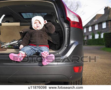 Baby sitting in open car boot View Large Photo Image Stock Photo - Baby sitting in open car boot. Fotosearch
