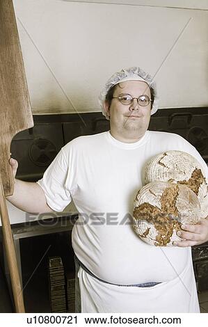 Stock Image - Bakerman standing in front of an oven. Fotosearch
