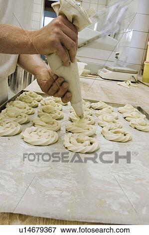 Stock Photo - Bakerman working on sweet cookies. Fotosearch