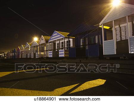 Stock Image - Beach huts at night. Fotosearch