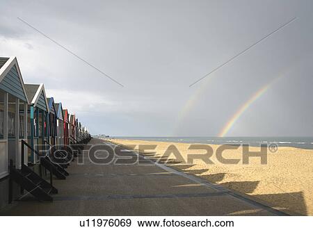 Stock Photo - Beach huts with double rainbow. Fotosearch